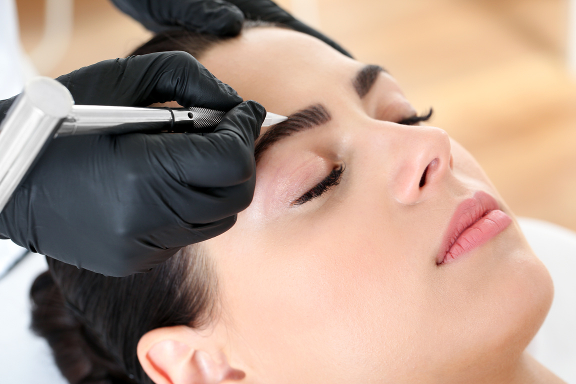 Young Woman Undergoing Procedure of Eyebrow Micro Blading